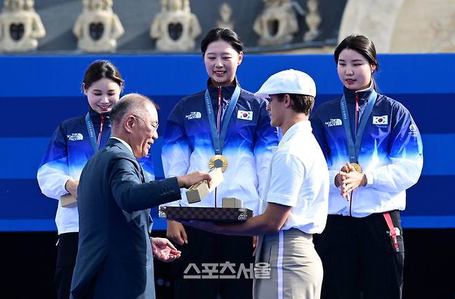 여자 양궁 대표팀의 전훈영(왼쪽부터), 임시현, 남수현이 28일(한국시간) 프랑스 파리 앵발리드에서 열린 2024 파리올림픽 양궁 여자 리커브 단체 결승에서 중국을 꺾고 10회 연속 금메달의 대기록을 달성한 뒤 시상대 위에서 정의선 회장이 건네는 기념품을 받고 있다. 파리 | 박진업 기자 upandup@sportsseoul.com