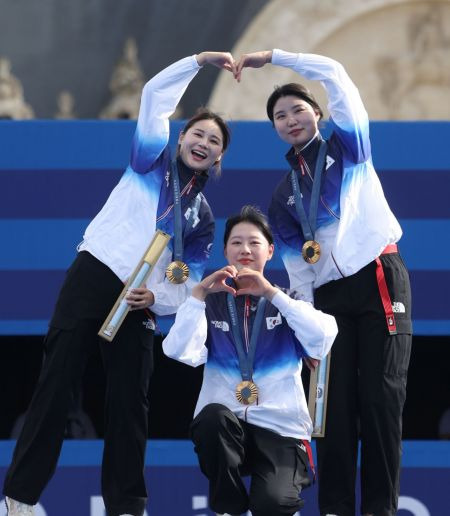 전훈영과 남수현, 임시현(왼쪽부터 시계방향으로)이 2024 파리올림픽 양궁 단체전에서 10연패에 성공한 뒤 금메달을 목에 걸고 하트 모양을 만들고 있다. [사진제공=연합뉴스]