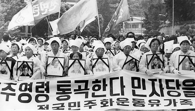 1990년 6월10일 성균관대에서 ‘제1회 전국민족민주열사 합동추모제 및 6월항쟁 계승 국민결의대회’를 끝낸 뒤 유가협 어머니들이 소복 차림으로 자식들 112명의 영정사진을 든 채 평화행진에 나서고 있다. 경찰의 저지로 행진은 중단됐고 청년학생들은 격렬한 시위를 벌였다. 한겨레 자료사진