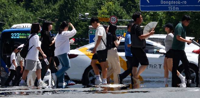 Pedestrians walk amid the heat haze forming above the streets in Daegu, Monday, where daytime temperatures reached as high as 36 degrees Celsius. (Yonhap)