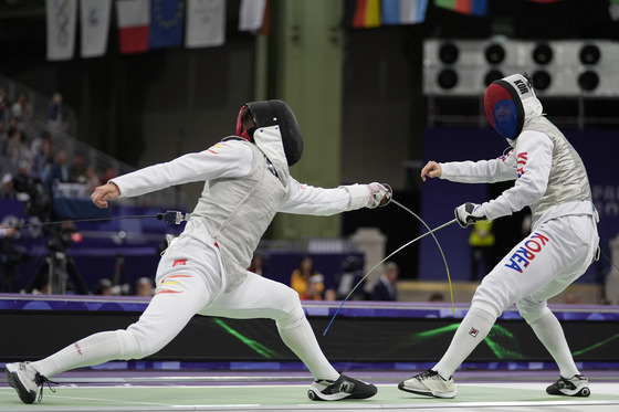 Korean fencer Ha Tae-gyu, right, competes against Carlos Llavador of Spain in the men's foil individual table of 32 at the Paris Olympics at Grand Palais in Paris on Monday. [AP/YONHAP]