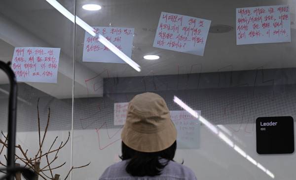 28일 서울 강남구 삼성동 위메프 본사 사무실 유리벽에 소비자들이 구영배 큐텐 대표를 규탄하는 문구가 여러 장 붙어 있다. 이날 사무실을 찾은 한 피해자가 해당 문구들을 바라보고 있다. 이한형 기자