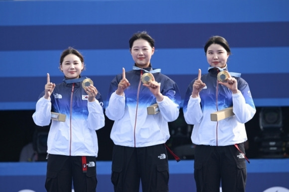 한국 양궁 여자 대표팀인 전훈영, 임시현, 남수현(오른쪽)  선수가 금메달을 목에 걸고 포즈를 취하고 있다.