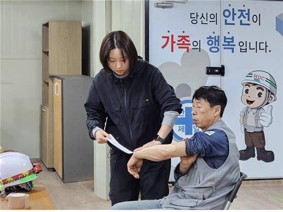 HDC현대산업개발 전문강사가 건설현장 근로자를 대상으로 테이핑 요법 교육을 하고 있다. [HDC현대산업개발 제공. 재판매 및 DB 금지]