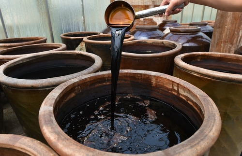 Shanxi Mature Vinegar shown by staff in Donghu Vinegar Garden