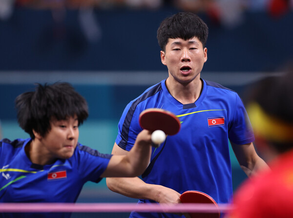 북한의 리정식과 김금용(왼쪽) 짝이 30일(한국시각) 열린 2024 파리올림픽 탁구 혼합복식 결승전에서 중국의 왕추진-쑨잉사 짝과 대결하고 있다.파리/연합뉴스