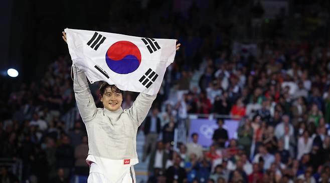 <yonhap photo-2902=""> 태극기 펼치는 오상욱 (파리=연합뉴스) 신준희 기자 = 27일(현지시간) 프랑스 파리 그랑 팔레에서 열린 2024 파리올림픽 펜싱 남자 사브르 결승전에서 파레스 페르자니(튀니지)를 꺾고 우승을 차지한 오상욱이 태극기를 펼치며 기뻐하고 있다. 2024.7.28 hama@yna.co.kr/2024-07-28 06:22:27/ <저작권자 ⓒ 1980-2024 ㈜연합뉴스. 무단 전재 재배포 금지, AI 학습 및 활용 금지></yonhap>