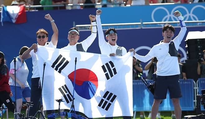 29일(현지시간) 프랑스 파리 레쟁발리드 양궁 경기장에서 열린 2024 파리올림픽 양궁 남자 단체 결승전 한국과 프랑스의 경기. 금메달을 차지한 한국 대표팀 선수들이 태극기를 들고 세리머니를 하고 있다.  사진=연합뉴스