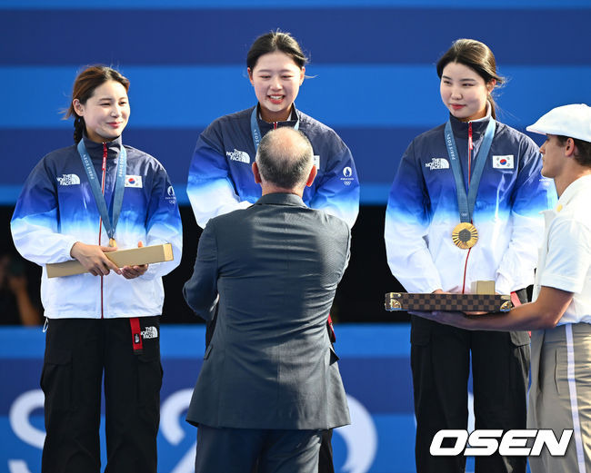 [OSEN=파리(프랑스), 최규한 기자] 한국 여자 양궁이 올림픽 10연패 대기록을 쐈다.임시현(한국체대), 남수현(순천시청), 전훈영(인천시청)으로 구성된 한국 양궁 대표팀은 프랑스 파리 앵발리드에서 열린 ‘2024 파리올림픽’ 양궁 여자 리커브 단체전 결승서 중국(안치쉬안, 리지아만, 양사오레이) 상대로 5-4(56-53, 55-54, 51-54, 53-55, 29-27)로 승리하면서 대회 10연패를 달성했다.금메달을 거머쥔 한국 임시현-남수현-전훈영이 시상자로 나선 정의선 현대차 회장에게 기념품을 받고 있다. 2024.07.29 / dreamer@osen.co.kr