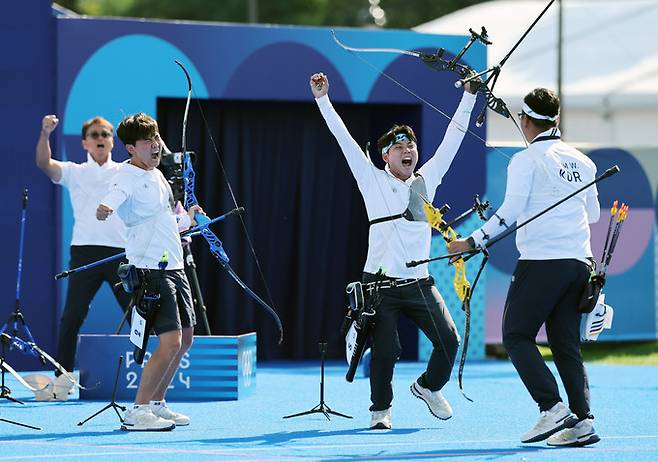 김우진, 김제덕, 이우석이 29일(현지시간) 프랑스 파리 레쟁발리드에서 열린 파리 올림픽 양궁 남자 단체전 결승 프랑스와의 경기에서 승리하며 금메달을 확정한 뒤 환호하고 있다. 뉴시스