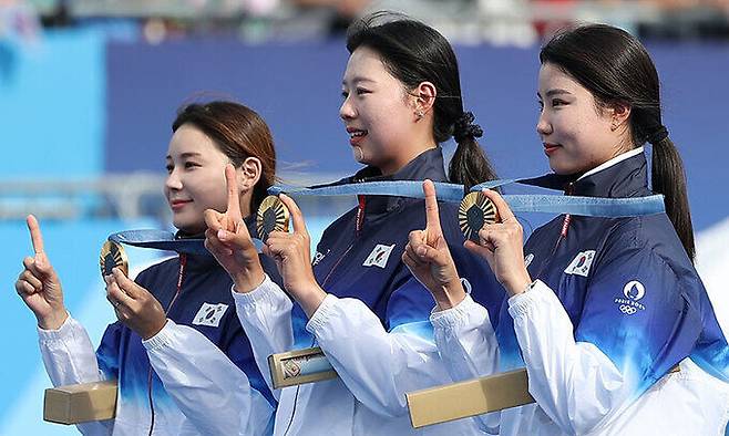 올림픽 10연패를 달성한 한국 여자 양궁대표팀 전훈영, 임시현, 남수현이 지난 28일(현지시간) 프랑스 파리 레쟁발리드 양궁 경기장에서 열린 2024 파리올림픽 양궁 여자단체전 시상식에서 손가락과 금메달을 이용해 10회 연속 우승을 표시해 보이고 있다. 연합뉴스