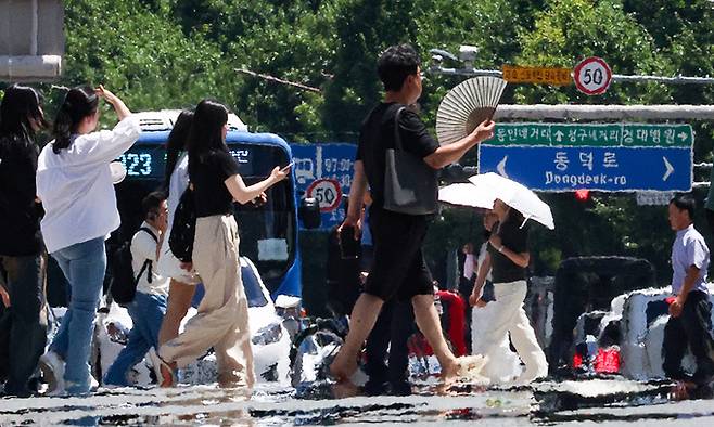 폭염 경보가 발효 중인 29일 대구 중구 공평네거리에서 시민들이 지열로 인한 아지랑이가 피어오르는 도로를 지나가고 있다. 연합뉴스