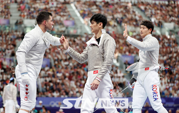 오상욱, 구본길이 31일(현지시각) 프랑스 파리 그랑 팔레에서 열린 2024 파리 올림픽 펜싱 남자 사브르 단체 8강 캐나다와의 경기에서 승리하며 준결승 진출을 확정 지은 뒤 상대 선수와 인사하고 있다. 사진┃파리=뉴시스