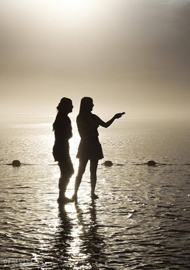 지난 26일 다대포해수욕장을 찾은 여행객들이 짙은 구름 속에서 잠시 햇살이 비치자 인증사진을 찍고 있다. 근래 노을 명소로 소문나며 젊은 층이 많이 찾고 있다.