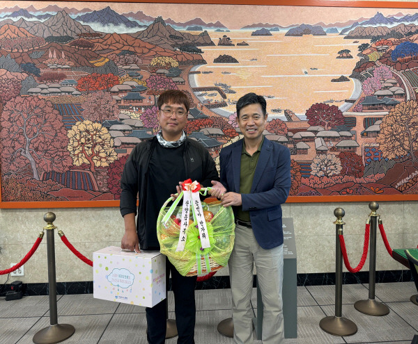 경남 통영시 황재열 산양읍장(사진 오른쪽)이 축하 선물을 전달하고 있다. 통영시 제공