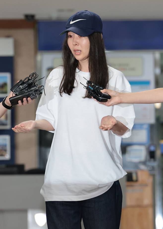 Ador CEO Min Hee-jin responds to reporters' questions as she leaves Yongsan Police Station in Seoul on July 9 after being questioned on a breach of trust allegation. (Yonhap)