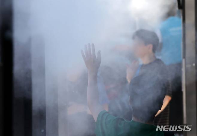 [부산=뉴시스] 하경민 기자 = 부산지역에 폭염경보가 발효 중인 30일 동구 부산진역 인근을 지나는 시민들이 쿨링포그를 맞으며 더위를 식히고 있다. 2024.07.30. yulnetphoto@newsis.com