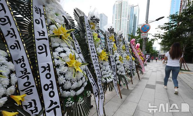 [서울=뉴시스] 추상철 기자 = 31일 오후 서울 용산구 하이브 사옥 앞에 그룹 뉴진스의 팬들이 보낸 근조화환이 놓여 있다. 뉴진스 팬들은 하이브 사옥 앞에서 뉴진스 소속사 어도어 및 민희진 대표를 지지하는 트럭 시위를 벌여 왔으며 이날 근조화환 설치를 하는 등 시위를 이어갔다. 2024.07.31. scchoo@newsis.com