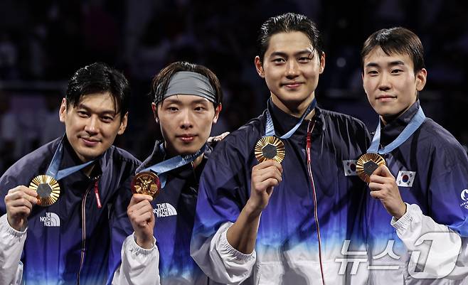 대한민국 펜싱 대표팀 구본길, 오상욱, 박상원, 도경동이 1일(한국시간) 프랑스 파리 그랑 팔레에서 열린 2024 파리올림픽 펜싱 남자 사브르 단체 시상식에서 수여 받은 금메달을 들어보이고 있다. 2024.8.1/뉴스1 ⓒ News1 이동해 기자