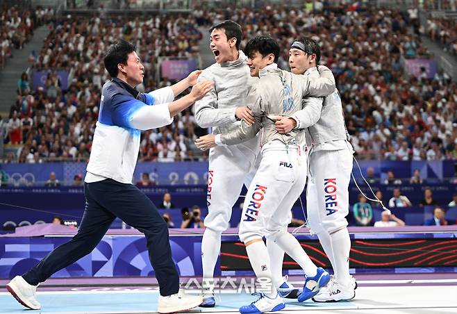 펜싱 사브르 남자 단체 대표팀이 31일(한국 시간) 프랑스 파리 그랑팔레에서 열린 2024 파리올림픽 펜싱 남자 사브르 단체전 프랑스와의 준결승전에 서 승리한 뒤 원우영 감독과 함께 기뻐하고 있다. 2024.7.31. 파리 | 박진업 기자 upandup@sportsseoul.com