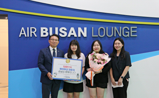 1일 김해공항 에어부산 라운지에서 (왼쪽 첫번째)마호진 에어부산 영업본부장과 관계자들이 10만 번째 입장객에게 국제선 왕복항공권과 기념품을 전달하고 있다. 에어부산 제공