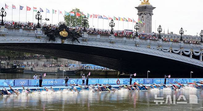 [파리=뉴시스] 김진아 기자 = 수질 논란이 계속되는 프랑스 파리 센강에서 직접 헤엄친 2024 파리 올림픽 트라이애슬론(철인 3종) 선수 대부분은 문제없었다고 입을 모았다. 사진은 지난달 31일(현지시각) 프랑스 파리 알렉상드르 3세 다리 인근 센강에서 열린 2024 파리 올림픽 트라이애슬론(철인 3종 경기) 남자 개인전에서 선수들이 입수하고 있는 모습. 2024.08.01. bluesoda@newsis.com