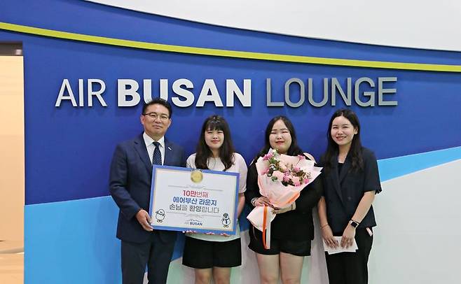 [부산=뉴시스] 1일 김해공항 에어부산 라운지에서 에어부산 마호진(왼쪽에서 첫번째) 영업본부장과 관계자가 10만 번째 입장객에게 국제선 왕복항공권과 기념품을 전달한 후 기념 촬영을 하고 있다. (사진=에어부산 제공) 2024.08.01. photo @newsis.com *재판매 및 DB 금지