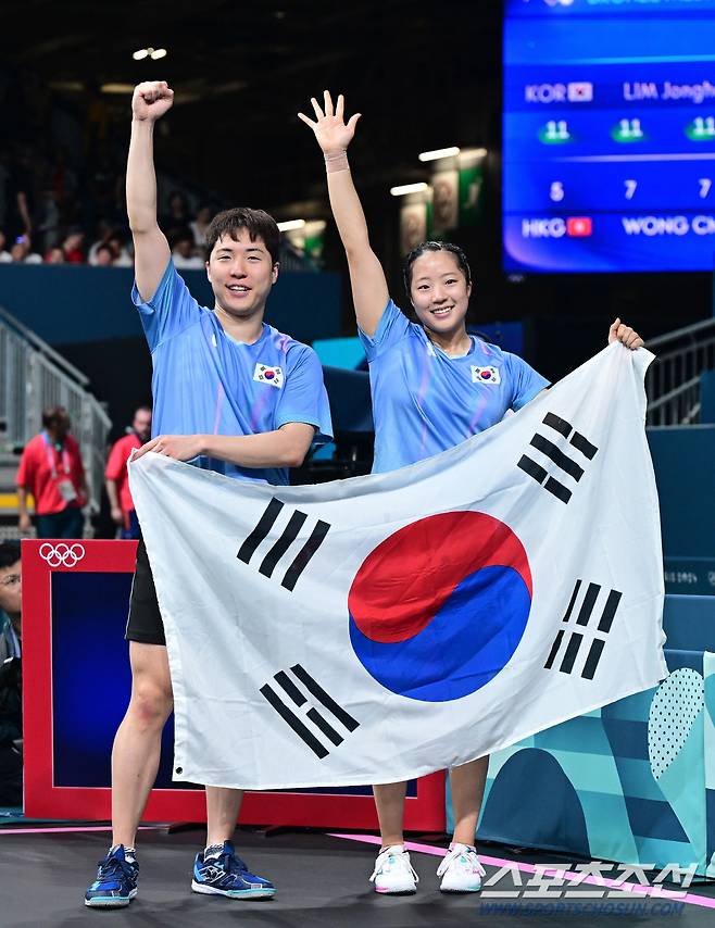 30일 (한국시각) 프랑스 파리 사우스 파리 아레나 4에서 '2024 파리올림픽' 탁구 혼합 복식 동메달결정전 대한민국 임종훈-신유빈 조와 홍콩의 웡춘팅-두호이켐 조의 경기가 열렸다. 동메달을 차지한 한국 임종훈-신유빈이 태극기를 펼치며 환호하고 있다. 파리(프랑스)=정재근 기자 cjg@sportschosun.com/2024.07.30/