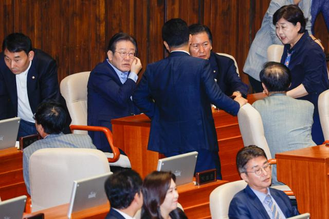 이재명(뒷줄 왼쪽 두 번째) 더불어민주당 의원이 2일 오후 서울 여의도 국회에서 열린 본회의에서 2024년 민생회복지원금 지급을 위한 특별조치법안(대안) 투표에 앞서 서영교, 정청래 의원 등과 대화하고 있다. 뉴스1