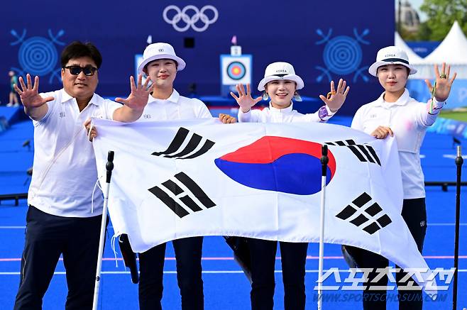 28일(한국시각) 프랑스 파리 앵발리드에서 열린 '2024 파리올림픽' 양궁 여자 리커브 단체전 금메달을 딴 한국 임시현, 전훈영, 남수현이 양창훈 감독과 함께 태극기를 휘날리고 있다. 파리(프랑스)=정재근 기자 cjg@sportschosun.com/2024.7.28/