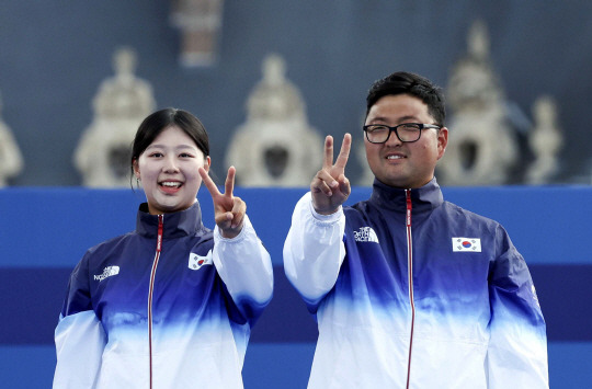 김우진과 임시현이 2일(현지시각) 프랑스 파리 앵발리드에서 열린 2024 파리 올림픽 양궁 혼성 단체 결승 시상식에서 손가락으로 2연패를 상징하는 숫자 ‘2’를 그리고 있다. 윤성호 기자