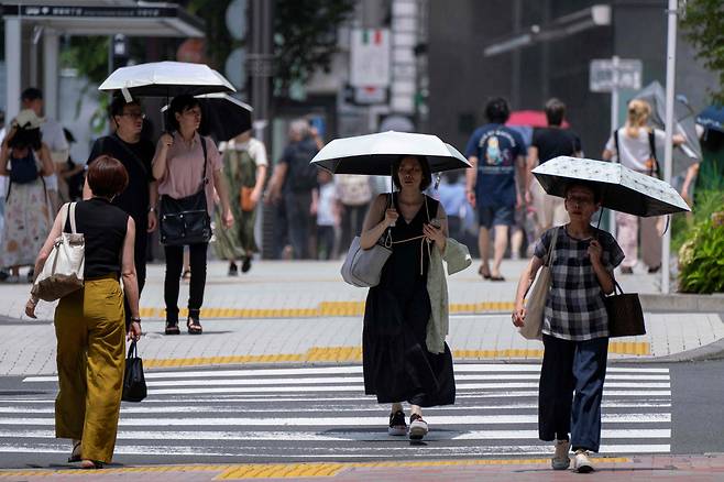 지난 7월 9일 일본 도쿄 도심에서 행인들이 양산을 쓰고 걸어가고 있다. /AFP 연합뉴스