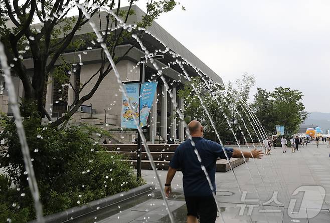 서울을 포함한 수도권 대부분 지역에 폭염경보가 내려진 5일 오후 외국인 관광객이 서울 종로구 광화문광장 분수 사이를 지나가며 더위를 식히고 있다. 2024.08.05/뉴스1 ⓒ News1 김종훈 기자