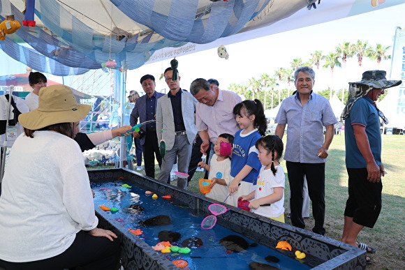 김완근 제주시장이 금능원담축제 현장을 방문하고, 어린이들과 이야기를 나누고 있다. [사진=제주시]