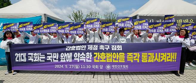 대한간호협회 소속 간호사들이 27일 서울 여의도 국회의사당 앞에서 '간호법안 제정 촉구 집회'를 연 뒤 21대 국회를 향해 간호법 통과를 촉구하며 구호를 외치고 있다. 뉴스1