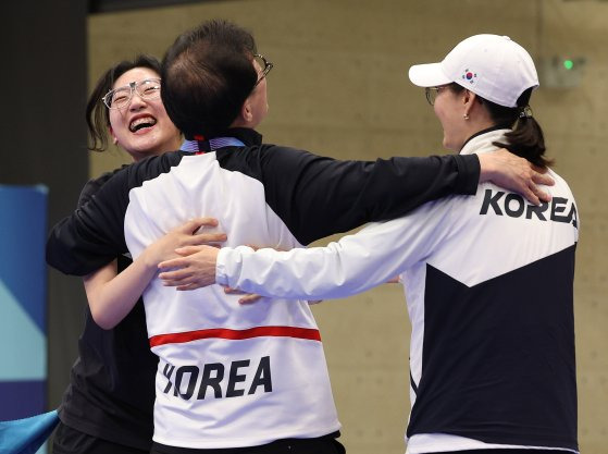 양지인(왼쪽)이 3일 파리올림픽 사격 25m 권총 여자 결선에서 금메달을 확정한 뒤 장갑석 총감독(가운데)과 기뻐하고 있다. 샤토루=김성룡 기자