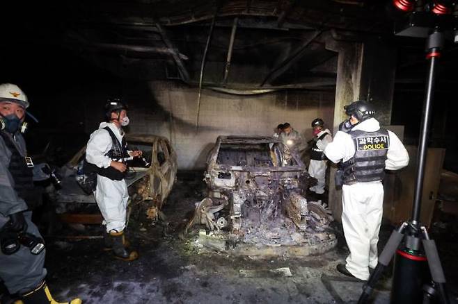 Police officers and firefighters are conducting a joint inspection at an underground parking lot of an apartment in Incheon, where a Mercedes-Benz electric car parked caught fire on August 1. Yonhap News