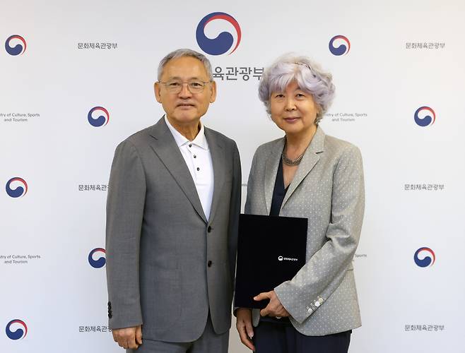 Culture Minister Yu In-chon (left) and Chon Soo-yong pose for photos after Chon's appointment as the president of the Literature Translation Institute of Korea at the National Museum of Modern and Contemporary Art in Jongno, Monday. (Ministry of Culture, Sports and Tourism)