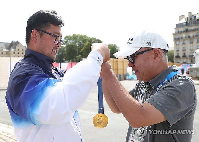 정의선 현대차 회장에게 금메달 걸어주는 김우진 (파리=연합뉴스) 신준희 기자 = 4일(현지시간) 프랑스 파리 레쟁발리드에서 열린 2024 파리올림픽 양궁 남자 개인전 결승전에서 승리해 금메달을 차지한 한국 김우진이 정의선 현대차 회장에게 금메달을 걸어주고 있다.2024.8.4 hama@yna.co.kr