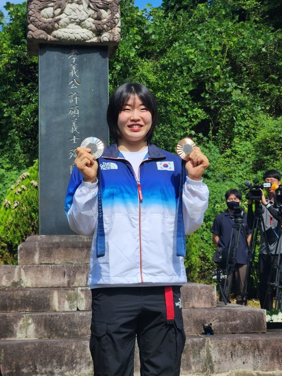 6일 오전 대구시 군위군 삼국유사면 허석 의사 묘소에서 파리 올림픽 유도 대표팀 허미미 선수가 올림픽 메달을 들어보이고 있다. 김정석 기자