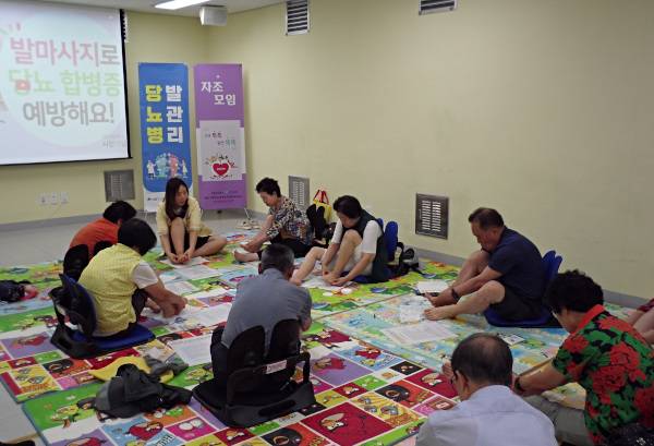 지난 6월 서울 성동구 고혈압·당뇨병 등록교육센터가 주최한 당뇨 환자 발 관리 교육에서 참가자들이 보건소 직원의 설명을 들으며 발을 살펴보고 있다. 성동구 고·당센터 제공