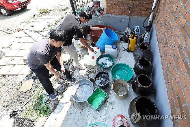 폭염에 단수…물 받기 위한 양동이들 (청도=연합뉴스) 윤관식 기자 = 5일 경북 청도군 풍각면 한 가정집이 단수된 가운데 풍각면사무소 직원이 급수 지원을 하고 있다.
청도군은 전체 물 사용량이 생산량을 넘어서면서 전날 오후부터 일부 지역에서 물을 사용하지 못하고 있다. 2024.8.5 psik@yna.co.kr