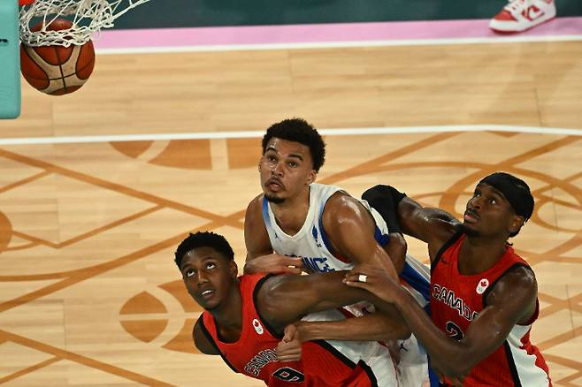 캐나다 선수들과 골밑에서 경합하는 프랑스의 빅터 웸반야마. 연합뉴스