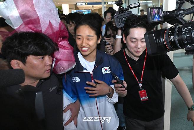 파리 올림픽 배드민턴 여자 단식 금메달리스트 안세영이 7일 인천공항 입국장에서 취재진 잘문에 답변 후 빠져나가고 있다 영종도 | 문재원 기자