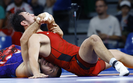 Korea's Kim Seung-jun, right, in action with Rustam Assakalov of Uzbekistan in the repechage round of the 97-kilogram Greco-Roman contest at the Paris Olympics Wednesday. [REUTERS/YONHAP]