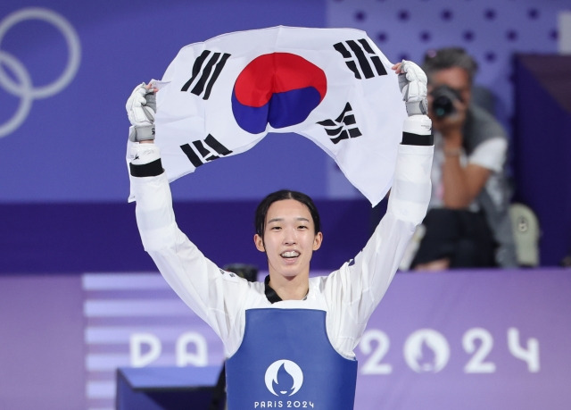 8일(현지시간) 프랑스 파리 그랑팔레 태권도경기장에서 열린 2024 파리올림픽 태권도 여자 57kg급 결승에서 한국의 김유진이 이란의 나히드 키야니찬데를 꺾고 금메달을 확정한 뒤 태극기를 들고 환호하고 있다. 연합뉴스