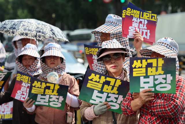 농민들이 6일 오후 서울역 인근에서 열린 전국농민회총연맹 쌀값 보장 촉구 집회에서 팻말을 들고 있다. 연합뉴스.