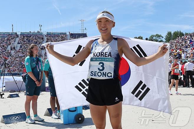 대한민국 근대5종 대표팀 성승민이 11일 오후(한국시간) 프랑스 파리 베르사유에서 열린 2024 파리올림픽 근대5종 여자 개인 결승전 레이저런 경기에서 3등으로 결승선을 통과한 뒤 태극기를 펼쳐 보이고 있다. 함께 출전한 김선우는 8위로 경기를 마쳤다. (공동취재) 2024.8.11/뉴스1