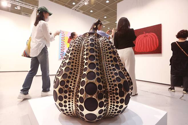 2023년 9월 서울 강남구 코엑스에서 열린 ‘프리즈 서울’(Frieze Seoul 2023)을 찾은 관람객들이 쿠사마 야요이 작품 〈호박〉을 살펴보고 있다. 최근 시장에서 구매자가 주로 찾는 쿠사마의 작품은 초기 작업이 아니라 그의 <호박> 작업이다. 연합뉴스