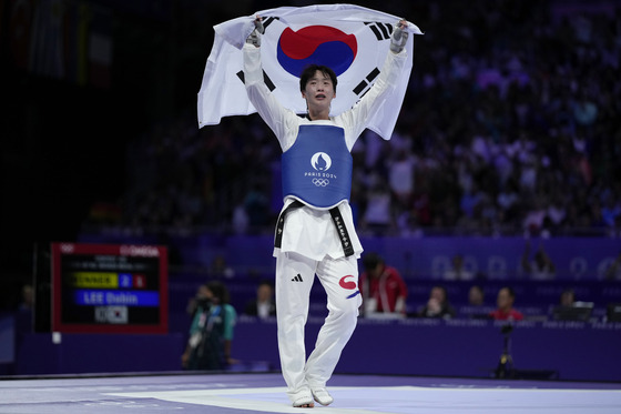 Korea's Lee Dabin celebrates after winning the women's +67-kilogram taekwondo bronze final match against Germany's Lorena Brandl during the Paris Olympics at the Grand Palais in Paris, on Saturday. [AP/YONHAP]